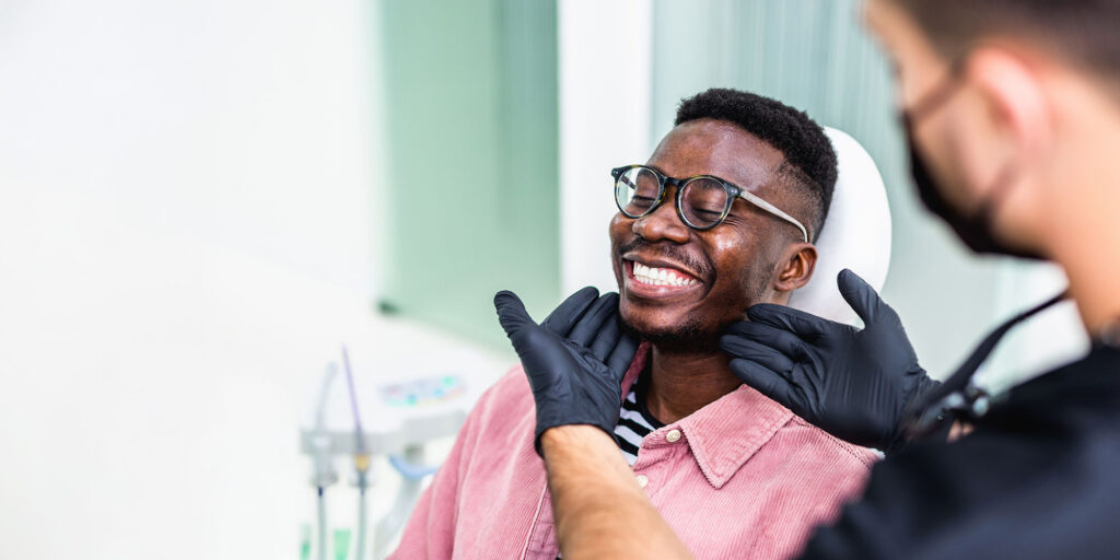 dr with dental patient holding smile